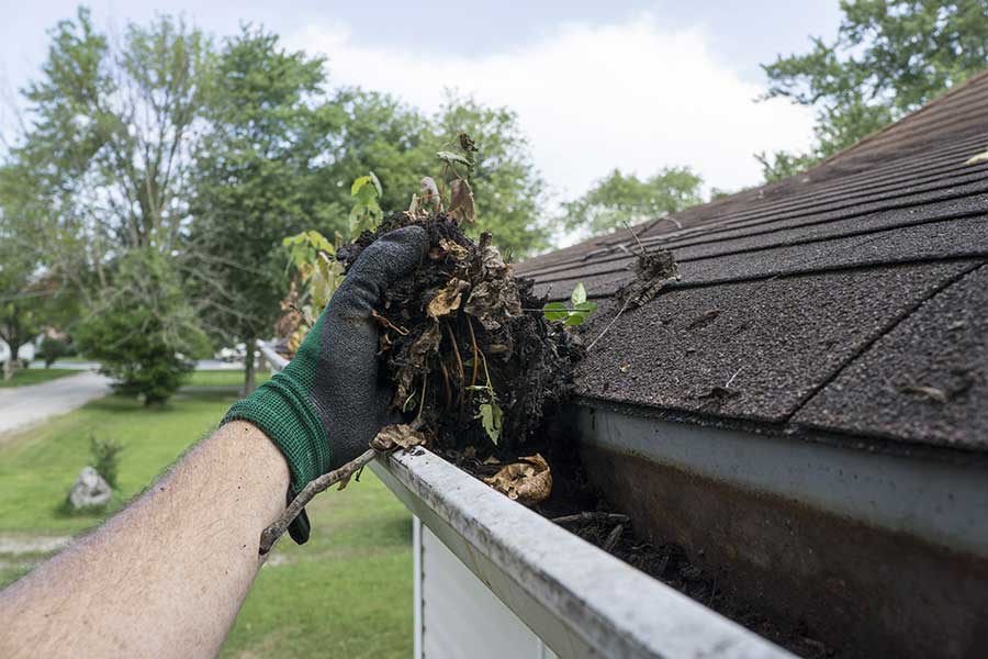 Clearing gutters to prevent surface water flooding